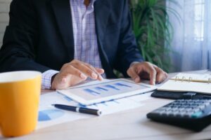 Founder reviewing financial charts on a tablet beside cash-flow paperwork